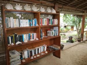 une étagère remplie de livres dans une pièce dans l'établissement Raja Laut Dive Resort Bunaken, à Bunaken