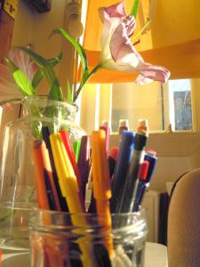 a glass jar filled with pens and a flower at MissOrtelia B&B in Amsterdam