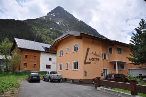 un edificio con una montaña en el fondo en Apart Lurega - inklusive Sommer Card, en Galtür