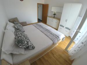 a bedroom with a large bed with pillows on it at Apartments Ljiljana in Trogir