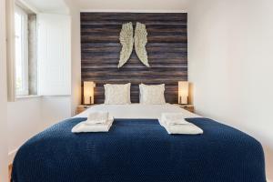 リスボンにあるSao Bento Blue One-Bedroom Apartment - by LU Holidaysのベッドルーム1室(ブルーベッド1台、タオル2枚付)