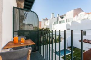 リスボンにあるSao Bento Blue One-Bedroom Apartment - by LU Holidaysの木製テーブルとオレンジジュース2杯付きのバルコニー