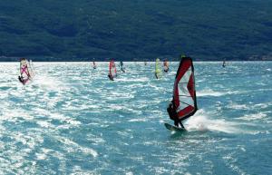 a group of people windsurfing on a body of water at Surf Hotel Pier - Montagnoli Group in Limone sul Garda