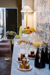 una mesa con comida y copas de vino. en Hôtel Henri IV Rive Gauche en París