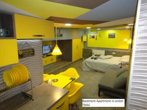 um quarto amarelo com uma cama e uma secretária em Apartment Premium Class in Batumi em Batumi