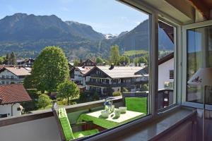 a balcony with a table and a view of mountains at Alpschatz Adlerhorst in Oberstdorf