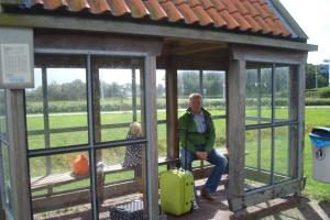 un uomo e una donna con una valigia in un gazebo di De Kapershut a Hollum