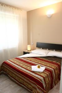 ein Schlafzimmer mit einem Bett mit einem weißen Handtuch darauf in der Unterkunft Residence La Dolce Vita in Rimini