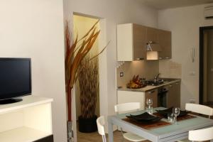 a living room with a table and a kitchen at Residence La Dolce Vita in Rimini