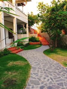 a stone walkway in front of a building with red benches at Minh Kha Hotel in Mui Ne