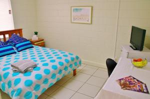 a bedroom with a bed and a table and a television at Accommodation @ Isa in Mount Isa