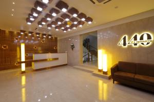 een lobby met een bank en een bord aan de muur bij Hotel 440, A Serene Stay in Ahmedabad