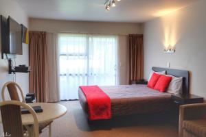 a hotel room with a bed with red pillows at Marksman Motor Inn in Wellington