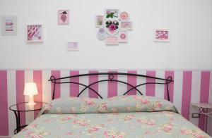 サレルノにあるSalerno nel cuore suiteのベッドルーム1室(ピンクと紫のストライプのベッド1台付)