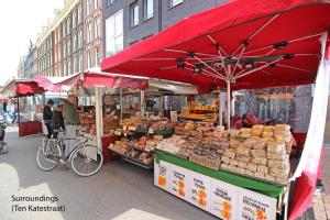 a market with a red umbrella on a street at New monumental garden view Studio in Amsterdam
