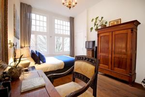 a bedroom with a bed and a desk and a table at New monumental garden view Studio in Amsterdam