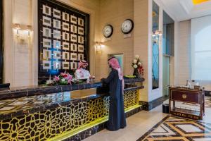 two women standing at a counter in a hotel lobby at Boudl Taif in Taif