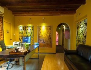 a living room with yellow walls and a desk at Sala Boutique Hotel in Male City