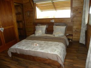 a bed in a wooden room with a window at Le Chalet - Destination St-Leu in Saint-Leu