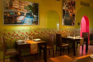 a dining room with two tables and chairs and a painting at Sala Boutique Hotel in Male City