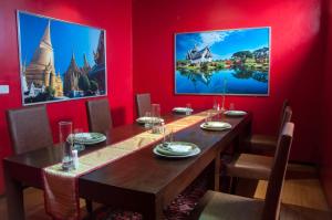 a dining room with a wooden table and red walls at Sala Boutique Hotel in Male City