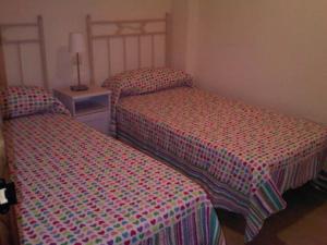 サアラ・デ・ロス・アトゥネスにあるAdosados La Tahonaのベッドルーム(ツインベッド2台、ナイトスタンド、ベッドスカート付)