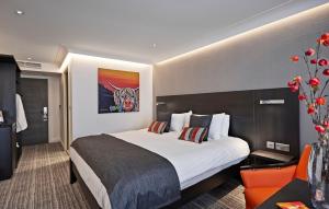 a hotel room with a large bed and a chair at The Old Palace Lodge in Dunstable