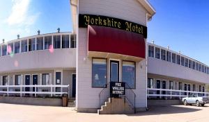 a white building with a sign on the front of it at Yorkshire Motel in York