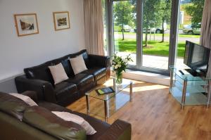 a living room filled with furniture and a tv at Ocean Serviced Apartments in Edinburgh