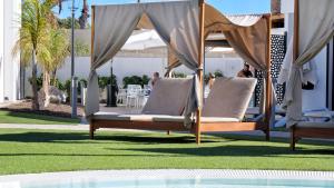 a couple of beds sitting next to a pool at FBC Fortuny Resort - Adults Only in Maspalomas