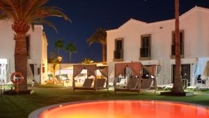 a pool in front of a house at night at FBC Fortuny Resort - Adults Only in Maspalomas
