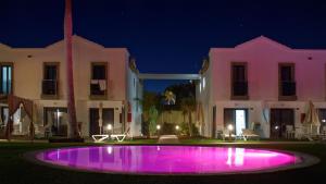 a pool in front of a house at night at FBC Fortuny Resort - Adults Only in Maspalomas
