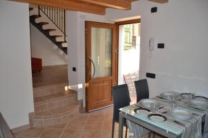 a dining room with a table and a staircase at Ca el Finilet in Brenzone sul Garda