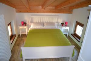 a large bed in a room with two windows at Ca el Finilet in Brenzone sul Garda
