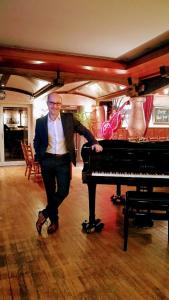 a man is standing next to a piano at Hotel Restaurant Albans Sonne in Bad Rippoldsau