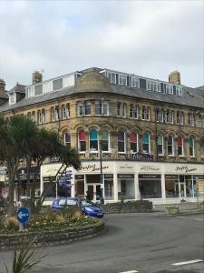 een groot gebouw met auto's ervoor geparkeerd bij Apartment 5, Cornerhouse Apartments in Llandudno