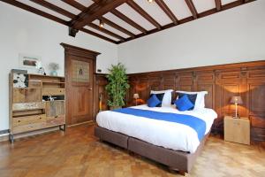 a large bedroom with a large bed with blue pillows at Large 2p canal apartment Prinsengracht in Amsterdam