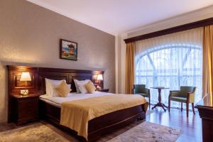 Un pat sau paturi într-o cameră la Grand Hotel Sofianu