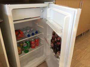 um frigorífico aberto cheio de refrigerantes e refrigerantes em Invicta house Boavista no Porto