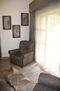 sala de estar con silla y ventana en Bush Lovers Lodge en Modimolle