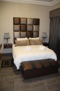 a bedroom with a large bed with a large headboard at Bush Lovers Lodge in Modimolle