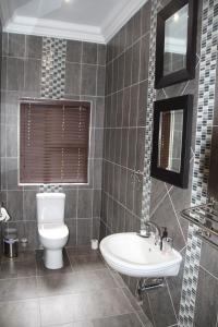 a bathroom with a toilet and a sink at Bush Lovers Lodge in Modimolle