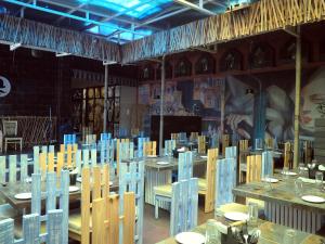 RAJA KA BAGH - A Boutique Hotel في Nūrpur: غرفة طعام مع طاولات وكراسي خشبية