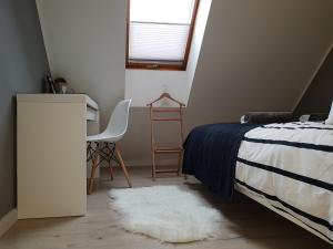 1 dormitorio con cama, escritorio y alfombra blanca en Black Rose APARTAMENT Targi 3 km, F-ry Vat, en Kielce