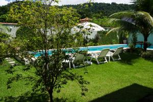 帕拉蒂的住宿－Casa Clara Paraty，一个带椅子的庭院和一个游泳池