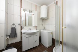 La salle de bains est pourvue d'un lavabo, de toilettes et d'un miroir. dans l'établissement Apartment Katia, à Zadar
