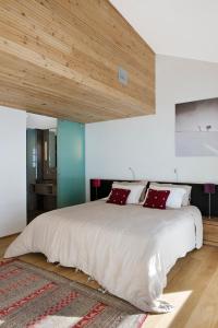 a bedroom with a large white bed with red pillows at Mineral Lodge & Spa in Villaroger