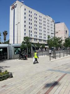 un homme marchant devant un grand bâtiment dans l'établissement Jerusalem Gold Hotel, à Jérusalem