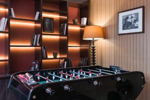 a room with a foosball table in front of a book shelf at Hôtel Sanso by HappyCulture in Paris