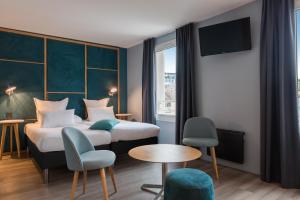 a hotel room with two beds and a tv at Hôtel Sanso by HappyCulture in Paris